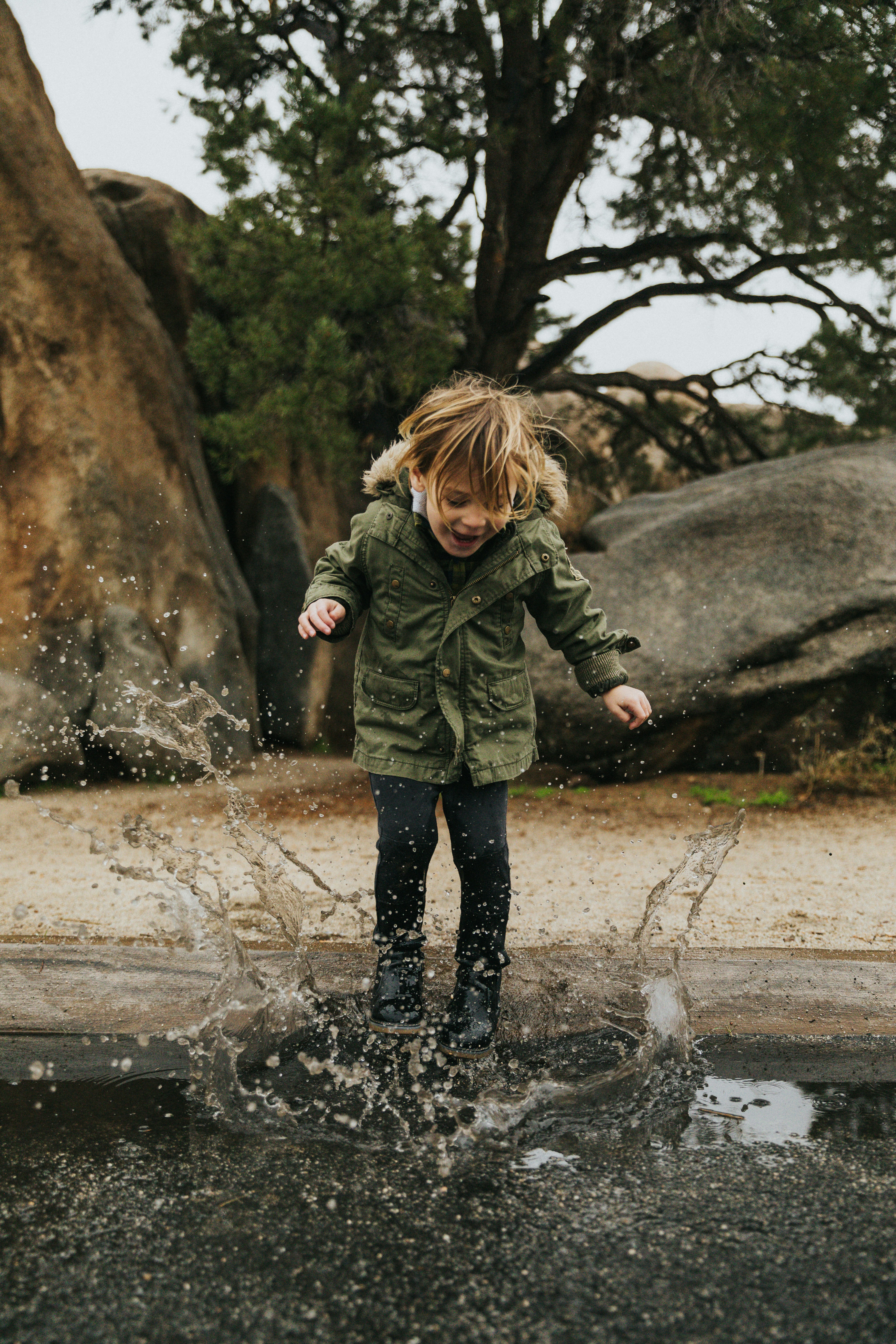 child jumping in a puddle